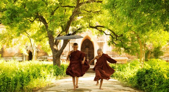 Two little monks running outdoors; Shutterstock ID 136179341